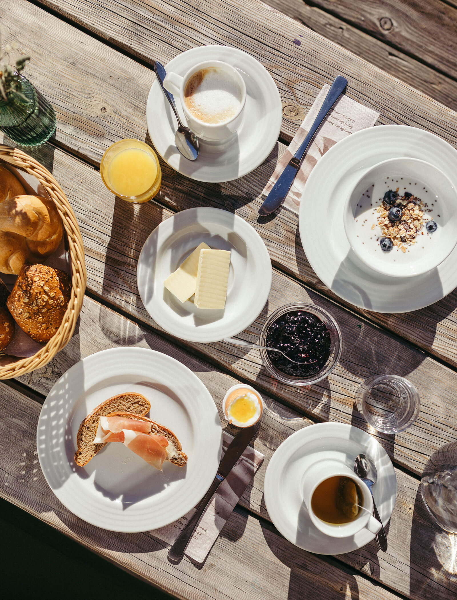 Tavolo della colazione all'aperto con uova sode, burro, yogurt e pane - Hofer